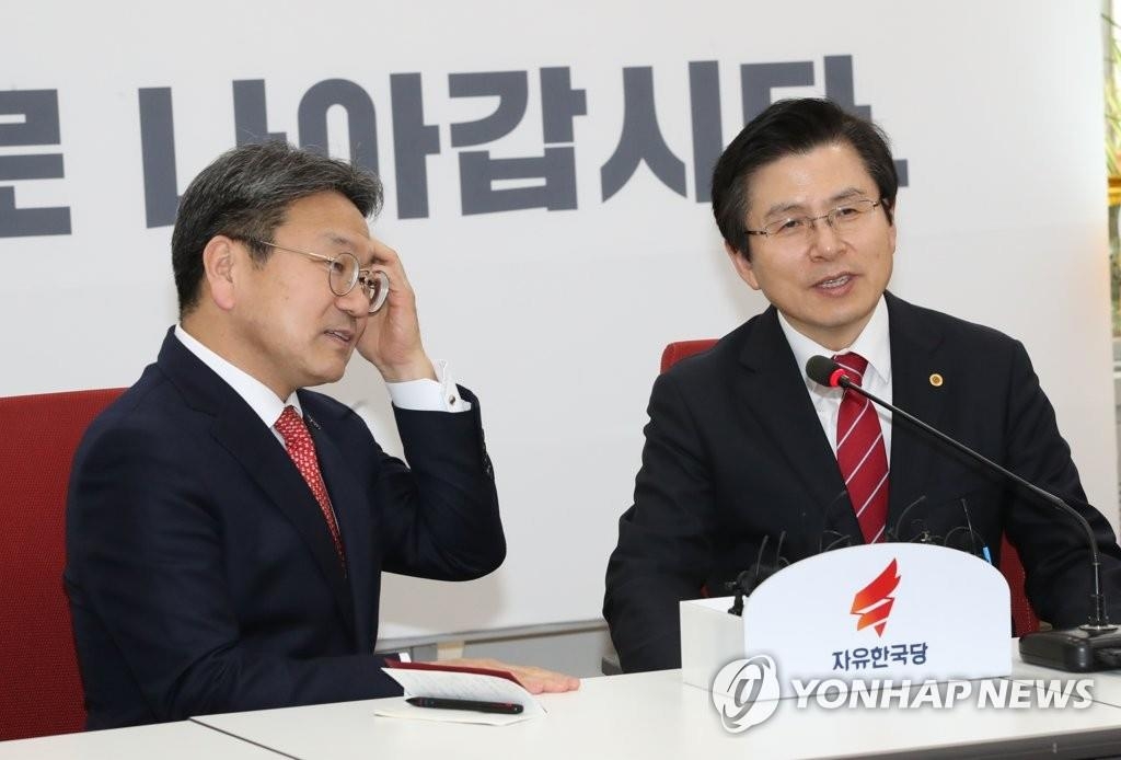In this file photo, taken on Feb. 28, 2019, Hwang Kyo-ahn (R), head of the main opposition Liberty Korea Party, talks with Kang Gi-jung, senior presidential secretary for political affairs, at the National Assembly in Seoul. (Yonhap)