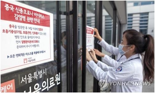 Hospital employees at Seoul Medical Center in the South Korean capital put up a notice informing people of risks associated with the Wuhan coronavirus on Jan. 24, 2020. (Yonhap)