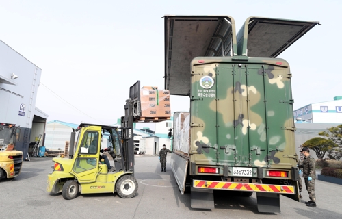 Boxes carrying face masks are loaded onto a military truck from the Transportation Command at a logistics center in Nonsan, 213 kilometers south of Seoul, on March 9, 2020, in this photo provided by the defense ministry. (PHOTO NOT FOR SALE) (Yonhap)