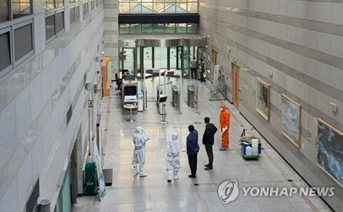 Soldiers and officials carry out disinfection work on the first basement level of the defense ministry's main building in Seoul on March 25, 2020. (Yonhap)