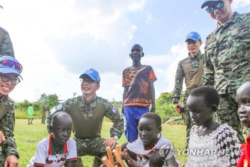Members of South Korea's Hanbit Unit play the Korean traditional folk game "yut" with children in South Sudan on Sept. 12, 2019, in this photo provided by the Joint Chiefs of Staff. (PHOTO NOT FOR SALE) (Yonhap)