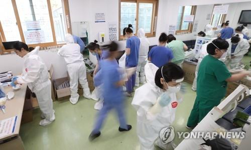 Medical staff at Dongsan Hospital in Daegu, 300 kilometers southeast of Seoul, put on protective gear as they get ready to treat novel coronavirus patients on April 9, 2020. (Yonhap)