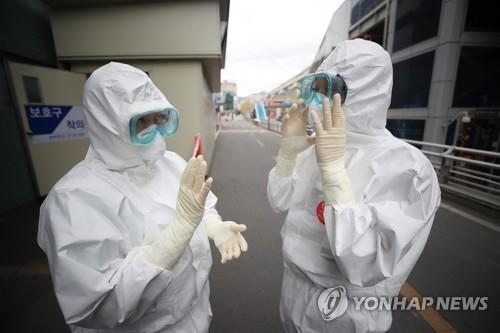 Medical workers in protective gear speak to each other before starting work at Keimyung University Dongsan Medical Center in Daegu, 300 kilometers southeast of Seoul, on April 13, 2020. (Yonhap)
