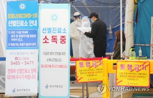 Health workers explain virus tests to a citizen at a public medical center in Gangseo District, western Seoul, on May 25, 2020. (Yonhap)