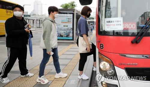 People wearing masks board a bus in Seoul on May 26, 2020. Health authorities said all bus, taxi and airplane passengers are required to wear masks to prevent COVID-19 infection. (Yonhap)