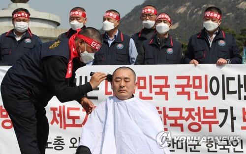 Choe Ung-sik, head of the labor union of South Korean employees for the U.S. Forces Korea, has his head shaved in protest over potential furloughs during a rally in Seoul on March 20, 2020, in this file photo. (Yonhap)