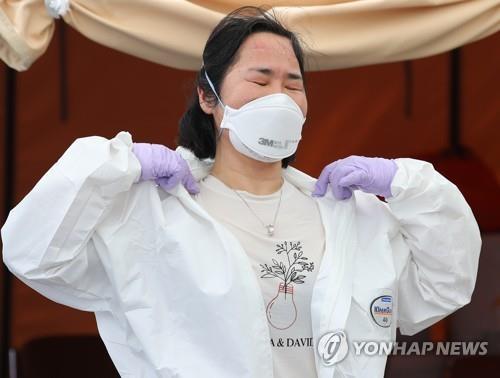 A medical professional takes off her protective suit after a morning shift at a coronavirus screening station in western Seoul on June 10, 2020. (Yonhap)