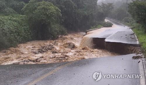 This photo provided by the National Fire Agency shows a collapsed road in Chungju, which left one firefighter missing on Aug. 2, 2020. (PHOTO NOT FOR SALE) (Yonhap)