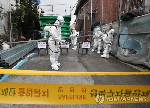 Public officials disinfect a church in Seoul's Seongbuk Ward on Aug. 14, 2020, following the detection of a cluster of new coronavirus infections at the church. The number of daily local virus cases in South Korea reached 103 the same day, jumping to an over four-month high as sporadic clusters in the greater Seoul area piled up. (Yonhap)