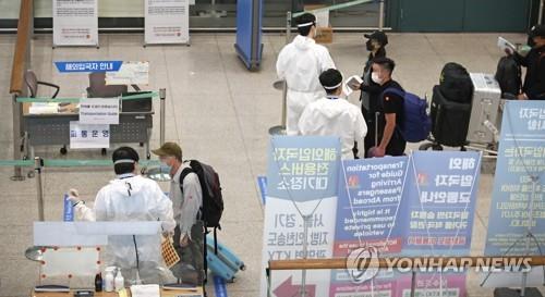 In this file photo, passengers arriving from overseas undergo a quarantine procedure at Incheon International Airport, west of Seoul, on July 15, 2020. (Yonhap)
