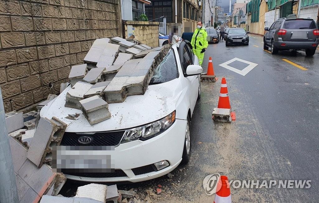A wall collapses over a parked car in Busan, South Korea, in this photo provided by the Busan Metropolitan Police Agency on Sept. 7, 2020. (PHOTO NOT FOR SALE) (Yonhap)