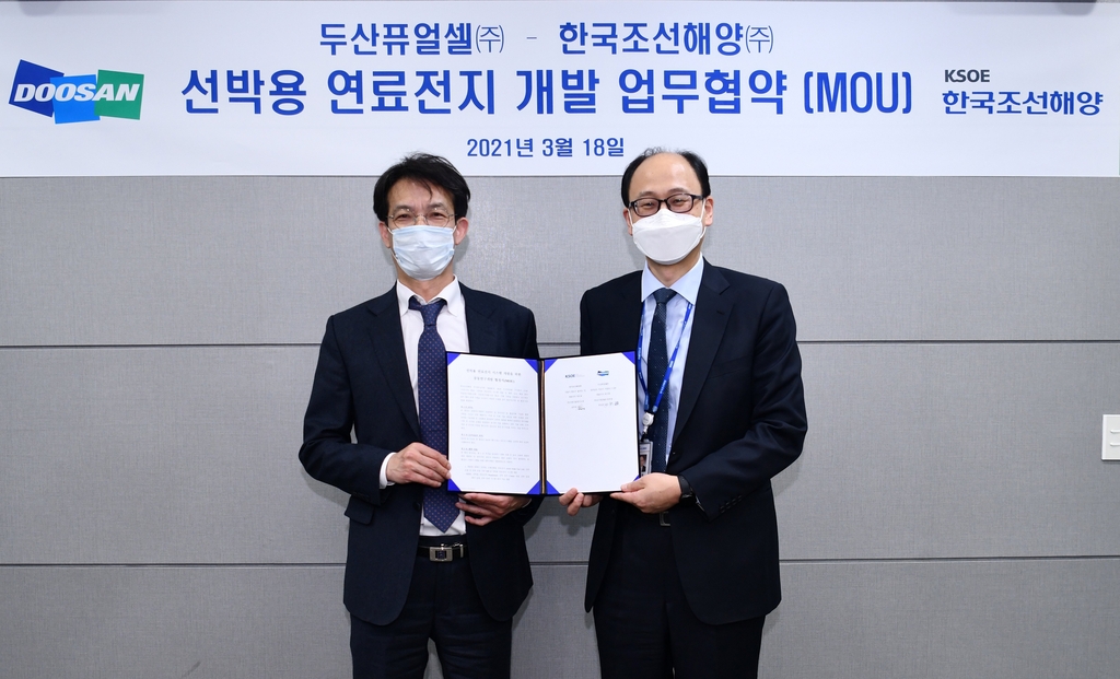 Two officials from Doosan Fuel Cell Co. and KSOE hold a business agreement to jointly develop solid oxide fuel cells (SOFCs), energy conversion devices generating electricity, to be used for ships on March 18, 2021, in this photo provided by the fuel cell maker. (PHOTO NOT FOR SALE) (Yonhap)