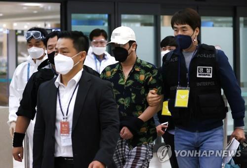 This Oct. 6, 2020, photo, taken at Incheon International Airport, shows the police repatriating the operator (C) of controversial doxing website Digital Prison. (Yonhap)