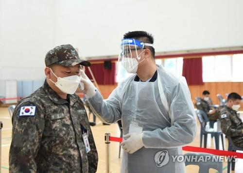 A service member of the Navy Submarine Force Command gets his temperature checked ahead of being vaccinated in the southeastern city of Changwon on April 28, 2021, in this photo provided by the defense ministry. (PHOTO NOT FOR SALE) (Yonhap) 