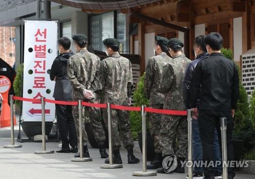 In this file photo, service members stand in line in front of a makeshift clinic in Seoul to undergo COVID-19 tests on April 26, 2021. (Yonhap)