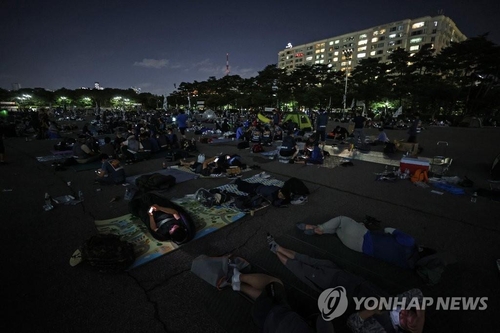 Unionized delivery workers spend a night outdoors at Yeouido Park in western Seoul, demanding logistics firms implement an agreement on preventing overwork on June 15, 2021. (Yonhap)