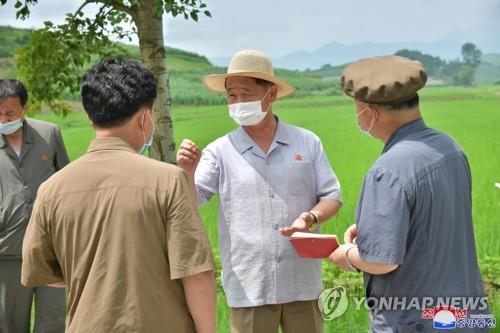 North Korean Premier Kim Tok-hun (C) visits a rice paddy at a cooperative farm as part of his inspection of fishery stations, cooperative farms, a construction site and other units in the country's eastern coastal area -- South Hamgyong and Kangwon provinces -- in this undated photo released by the Korean Central News Agency on July 20, 2021. (For Use Only in the Republic of Korea. No Redistribution) (Yonhap)