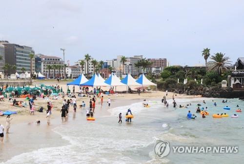 Hamdeok Beach on the southern resort island of Jeju bustles with vacationers on July 24, 2021. (Yonhap)