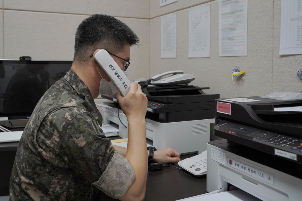 This photo, provided by the defense ministry on July 27, 2021, shows a South Korean service member using the inter-Korean western military communication line. (PHOTO NOT FOR SALE) (Yonhap) 