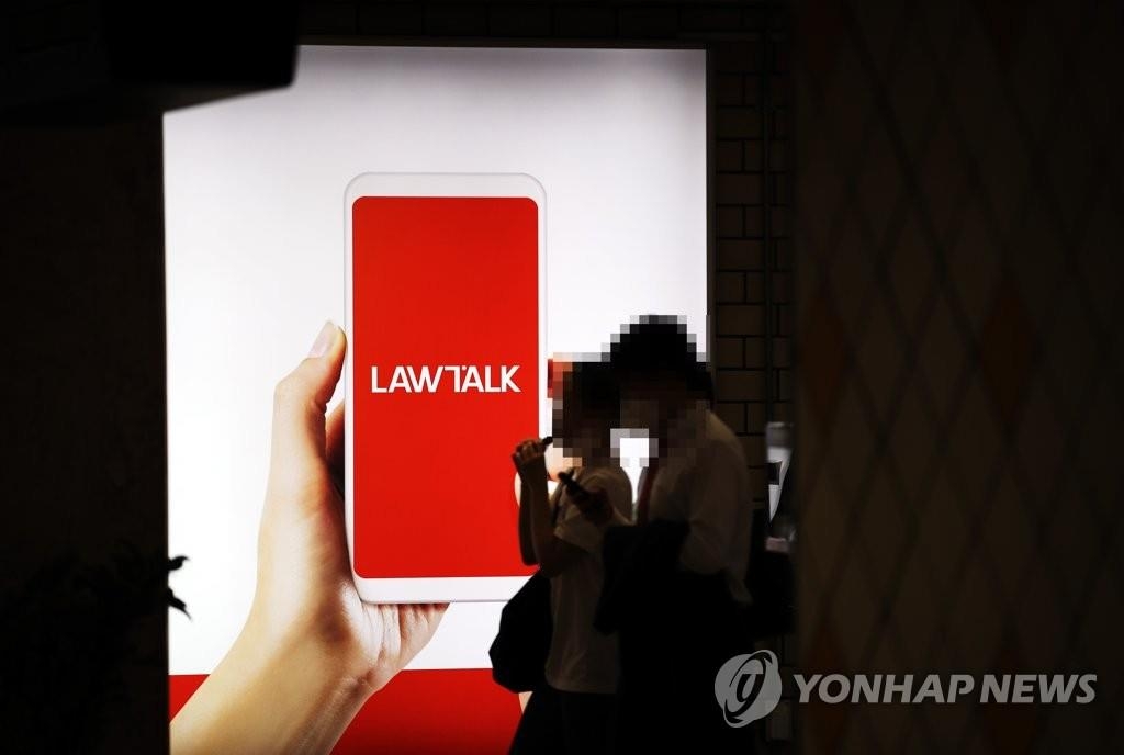 In this file photo, people pass by a billboard advertising LawTalk, an online service that connects clients and lawyers, in Seoul on July 4, 2021. (Yonhap)