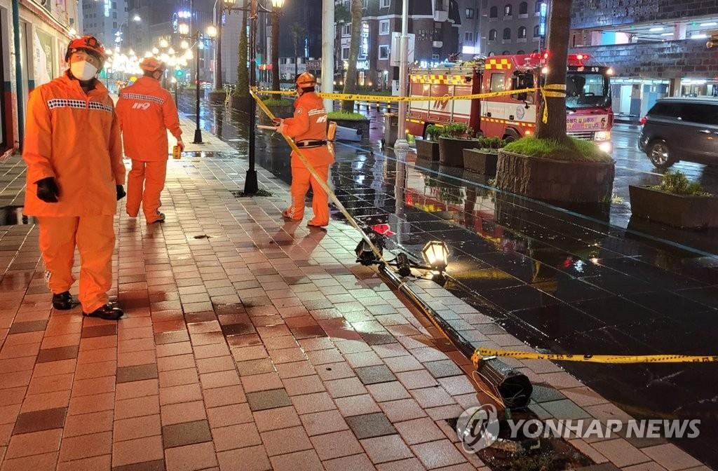 Firefighters respond to a downed streetlight in Jeju, South Korea, on Sept. 16, 2021, in this photo provided by the Jeju Fire Safety Headquarters. (PHOTO NOT FOR SALE) (Yonhap)