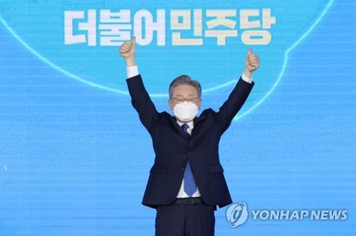 This photo, provided by the National Assembly press corps, shows Gyeonggi Province Gov. Lee Jae-myung posing for photos after winning the Democratic Party's nomination for president at a party event in Seoul on Oct. 10, 2021. (Yonhap)