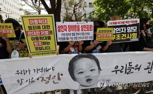 In this file photo, people demand stern punishments for the adoptive parents of 16-month-old Jung-in, who died in a fatal child abuse case, in front of the Seoul Southern District Court in Seoul on May 14, 2021. (Yonhap)