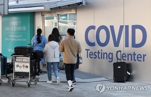 Entrants from overseas move to a COVID-19 testing station set up at Incheon International Airport, west of Seoul, upon arrival in South Korea on Jan. 12, 2022. (Yonhap) 