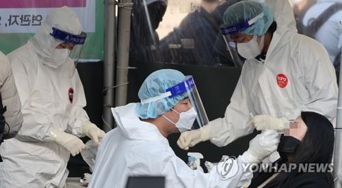 A health worker conducts a coronavirus test at a testing center at Seoul Station on March 7, 2022. (Yonhap)