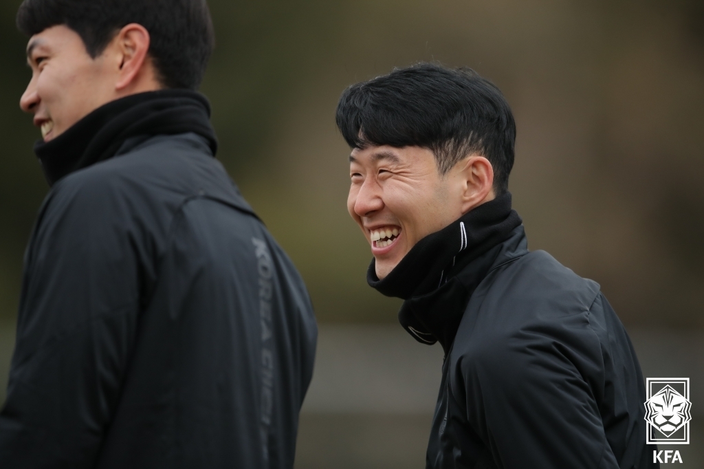 Son Heung-min of the South Korean men's national football team (R) smiles during a training session at the National Football Center in Paju, Gyeonggi Province, on March 23, 2022, on the eve of a World Cup qualifying match against Iran, in this photo provided by the Korea Football Association. (PHOTO NOT FOR SALE) (Yonhap)