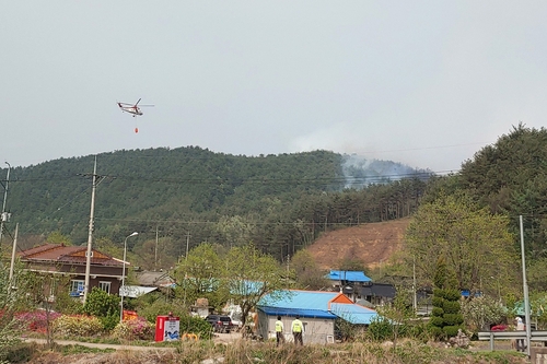 A helicopter fights a wildfire in the northeastern county of Yangyang on April 22, 2022, in this photo provided by the county office. (PHOTO NOT FOR SALE) (Yonhap)