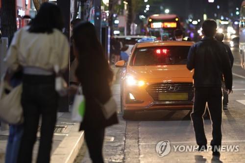 This file photo shows people trying to catch a taxi late at night in Seoul. (Yonhap)