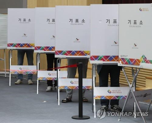 Voters mark ballots at polling booths at a voting center in Ulsan on May 27, 2022, the first day of two-day early voting for the June 1 local elections and parliamentary by-elections. (Yonhap)