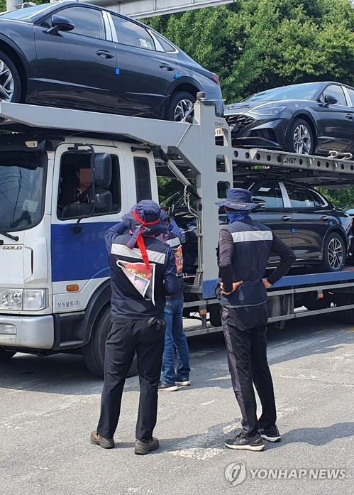 Unionized truckers of the militant Korean Confederation of Trade Unions attempt to stop a car hauler from leaving Hyundai Motor Co.'s plant in the city of Asan, about 85 kilometers south of Seoul, on June 8, 2022. (Yonhap)