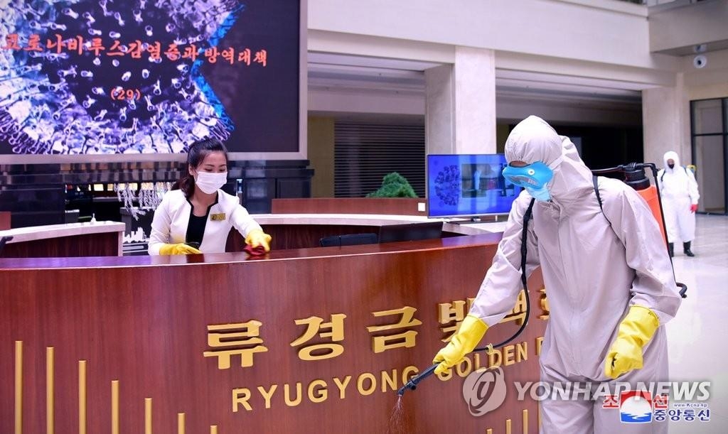In this photo released by the North's official Korean Central News Agency on June 15, 2022, North Korean workers conduct disinfection work at Ryugyong Golden Mall in Pyongyang. (For Use Only in the Republic of Korea. No Redistribution) (Yonhap)