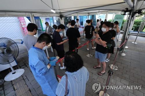 People line up at a COVID-19 testing center in central Seoul on Aug. 18, 2022. (Yonhap)