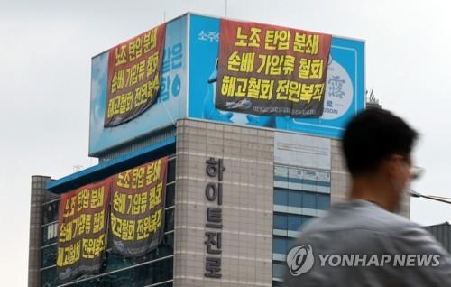 Protesting banners are displayed on the walls of Hite Jinro Co.'s Seoul headquarters by the members of the Cargo Truckers Solidarity on Aug. 23, 2022. (Yonhap)