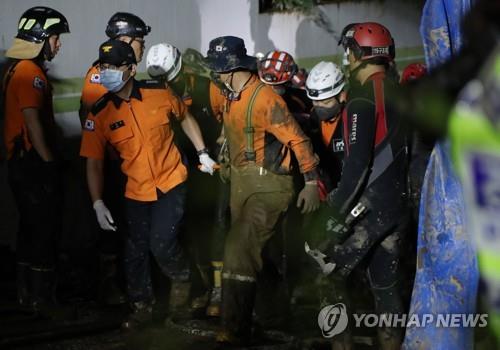Rescue workers carry a survivor out of the flooded underground parking lot of an apartment building in Pohang, North Gyeongsang Province, southeastern South Korea, on Sept. 6, 2022, after nine residents went missing following the torrential rains caused by Typhoon Hinnamnor that hit the region. (Yonhap)