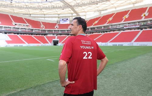 Former Iraq captain Younis Mahmoud poses in a T-shirt displaying his appointment as an ambassador for the 2022 FIFA World Cup in Qatar, in this photo provided by Qatar's World Cup organizing committee on Sept. 13, 2022. (PHOTO NOT FOR SALE) (Yonhap)