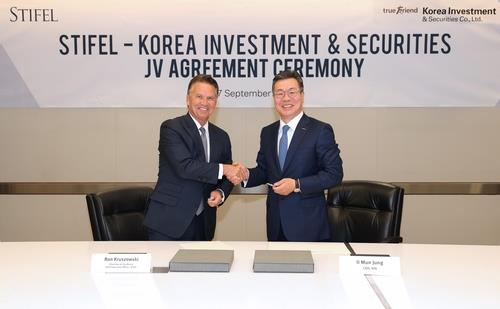 Korea Investment & Securities Co. chief Jung Il-moon and Stifel Financial Corp. head Ronald Kruszewski shake hands at the joint venture agreement ceremony on Sept. 27, 2022, in this photo provided by the South Korean firm. (PHOTO NOT FOR SALE) (Yonhap)