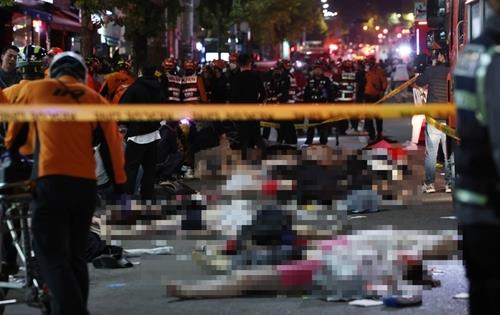 Rescuers attend to injured people on a street in Seoul's Itaewon area on Oct. 29, 2022. (Yonhap)