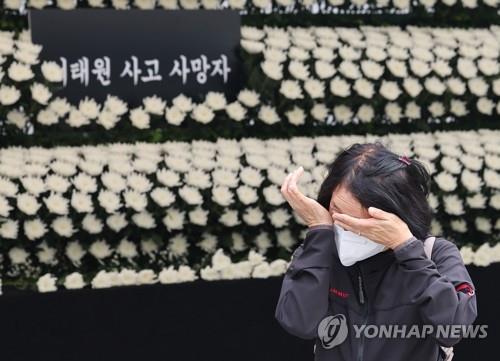 A woman wipes away tears after paying tribute at a mourning altar set up in Seoul's Yongsan Ward for the Itaewon crowd crush victims on Nov. 1, 2022. (Yonhap)
