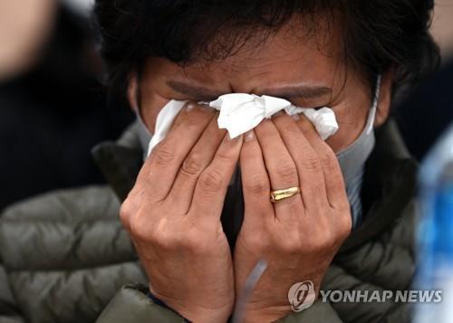 A family member of an Itaewon crowd crush victim wipes away tears during a news conference in southern Seoul on Nov. 22, 2022. (Pool photo) (Yonhap)