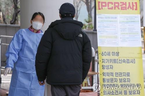 A medical workder guides a person at a COVID-19 test center in Seoul's Mapo district on Nov. 23, 2022. (Yonhap)