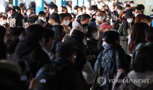 Passengers remain masked up inside a subway station in Seoul on March 14, 2023. (Yonhap)