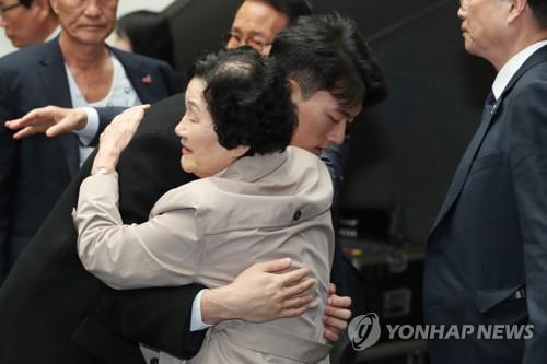Chun Woo-won (L), a grandson of the late former President Chun Doo-hwan, comforts a bereaved family member of a victim of the crackdown on a pro-democracy uprising in 1980 in the city of Gwangju, about 270 kilometers south of Seoul, on March 31, 2023.