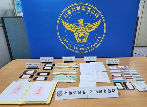 This undated photo, provided by the Seoul Subway Police, shows cash, mobile phones and other objects the police seized from the leader of a phone theft ring. (PHOTO NOT FOR SALE) (Yonhap)