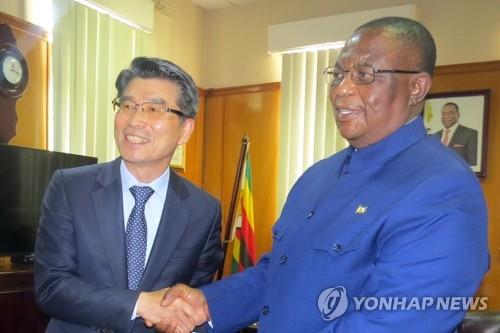 This file photo, provided by Hyundai Motor Group on Sept. 25, 2022, shows Zimbabwe's Vice President Constantino Chiwenga (R) shaking hands with Kia Corp. President and Chief Executive Song Ho-sung during a meeting in Harare. (PHOTO NOT FOR SALE) (Yonhap)