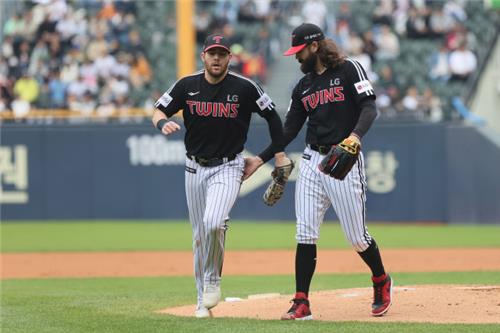 LG Twins starter Casey Kelly (R) pats first baseman Austin Dean during a Korea Baseball Organization regular season game against the Doosan Bears at Jamsil Baseball Stadium in Seoul on May 7, 2023, in this photo provided by the Twins. (PHOTO NOT FOR SALE) (Yonhap)