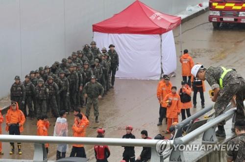 Rescuers and military personnel stand ready for a search operation on July 17, 2023, at an underground roadway in the central town of Osong where flooding caused by heavy rain claimed 13 lives. (Yonhap)